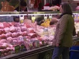 Una mujer observa los precios en el mostrador de una carnicer&iacute;a en Madrid.