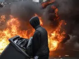 Un manifestante pasa por delante de las llamas en una protesta en París.