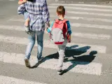 Foto de archivo de una mujer llevando a su hijo al colegio.