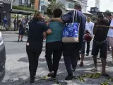 Familiares se abrazan en la guardería brasileña donde un atacante ha matado a cuatro niños.