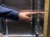 Un hombre utiliza el ascensor de un bloque de vivienda.