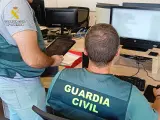 Especialistas en ciberdelincuencia de la Guardia Civil registran un ordenador.