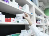 Farmacéutico cogiendo una caja de medicamentos.