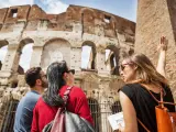 Turistas con un guía enseñándole el Coliseo de Roma.