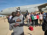 Los civiles bajan del avión del Ejército y se abrazan.