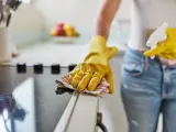 Imagen de recurso una mujer limpiando la cocina de su casa.