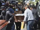 Los familiares de los mineros muertos llevan ataúdes vacíos mientras se preparan para recibir sus cuerpos en la morgue de la ciudad de Arequipa, Perú, el lunes 8 de mayo de 2023.