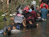 Varios inmigrantes cruzan el río Bravo, frontera entre México y EE UU, en Matamoros.