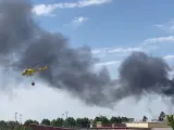 Un helicóptero trabaja en la extinción del incendio en un polígono industrial de Almendralejo