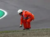 Un comisario retira desperfectos de un monoplaza en el circuito de Imola durante el GP de Emilia-Romaña de 2022.