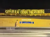 Pancarta con "Sevilla odia Nervión" y un muñeco colgando.