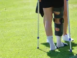 Una persona lesionada camina con ayuda de unas muletas.