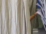 Una mujer ejerce su derecho al voto este 28M en una cabina instalada en un colegio electoral del centro de Sevilla.