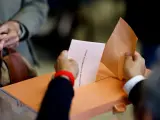 Una votante ejerce su derecho al voto en un colegio electoral de Madrid, este domingo.