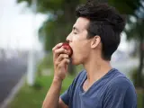 Un chico comiendo una manzana.
