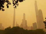 Varios de los rascacielos de Manhattan vistos desde Central Park entre una neblina anaranjada, consecuencia del humo producido por los incendios de Canad&aacute;.