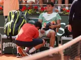 Alcaraz recibe atención médica tras lesionarse en Roland Garros.