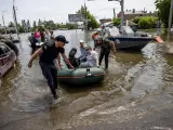 Varios rescatistas ayudan a evacuar a residentes afectados de las inundaciones en Jersón, Ucrania.