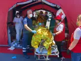Paramédicos del Servicio Nacional de Ambulancias de Emergencia de Grecia (EKAV) y miembros de la Cruz Roja griega ayudan a migrantes supervivientes del hundimiento de un pesquero en su llegada en el puerto de Kalamata este miércoles