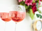 Dos copas de vino rosado con hielo.