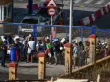 Cientos de personas, la mayoría marroquíes, guardan cola en la oficina para tramitar los asilos situada en la frontera del Tarajal que separa Ceuta de Marruecos, a 3 de agosto de 2021, en Ceuta (España).