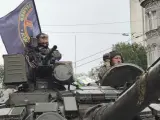 Milicianos del Grupo Wagner permanecen en un tanque con una bandera de la compañía de mercenarios, mientras montan guardia en una calle de Rostov.