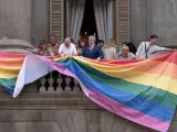 El alcalde de Barcelona, Jaume Collboni, ayuda a colgar la bandera LGTBIQ+.