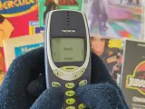 Nostalgia Milenial sujetanto un Nokia 3310.