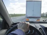 Un conductor circula detrás de un camión.