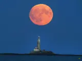 La luna llena del ciervo ilumina el faro de St Marys, en la Bahía de Whitley al noroeste de Inglaterra.