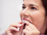 Mujer colocándose la férula dental