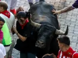 Una chica se salva por cent&iacute;metros de ser cogida por uno de los toros de Miura, en el &uacute;ltimo encierro de los Sanfermines 2023.