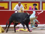 El diestro Rubén Pinar sufre una cogida durante la lidia al primer toro de la tarde, en los Sanfermines 2023.