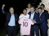 El jugador del Inter de Miami Lionel Messi, centro izquierda, sostiene su nueva camiseta del equipo mientras posa con los copropietarios del equipo Jorge Mas, izquierda, José Mas, segundo derecha, y David Beckham, derecha, mientras es presentado durante una celebración del equipo en el estadio DRV PNK.