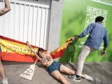 Una persona trata de impedir una protesta del colectivo activista Femen frente a la sede nacional de Vox, a 18 de julio de 2023, en Madrid (España).