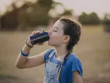 Una niña tomando un refresco.