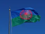 La bandera gitana representa el cielo, en color azul, el campo verde y la rueda simboliza la libre circulación.