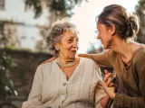 Mujer joven hablando con una persona mayor.