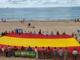 Simpatizantes de Vox despliegan una bandera de España en la playa de El Sardinero.