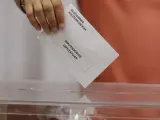 Una persona, ante una urna en un colegio electoral en Bilbao, durante los preparativos para el 23J.