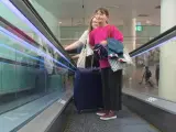 Una mujer en el aeropuerto regresando de sus vacaciones para ir a votar este 23J.