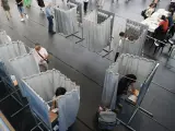 Varios votantes ejercen su derecho al voto en las elecciones generales en un colegio electoral de Santiago de Compostela este domingo.