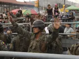 Un soldado pide calma a los amigos y familiares de los reclusos que buscan información después de los enfrentamientos mortales en la Penitenciaría del Litoral, en Guayaquil, Ecuador, martes 25 de julio de 2023.