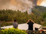 Dos vecinos observan las llamas del incendio forestal que se declaró en La Palma el pasado 15 de julio.