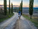 Pareja en bicicleta por los caminos rurales de la Toscana.