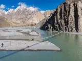 Puente colgante de Hussaini y montañas del Himalaya al fondo