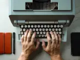 Una máquina de escribir, siendo utilizada por una persona