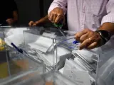 Trabajadores de la junta electoral y representantes de partidos políticos recuentan votos emitidos por los residentes en el extranjero.