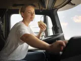Una mujer come mientras conduce.