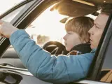 Un padre deja que su hijo este al volante de su coche.